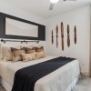 a bedroom with a nightstand, dresser and a window