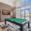 a clubhouse room with a pool table and a large window