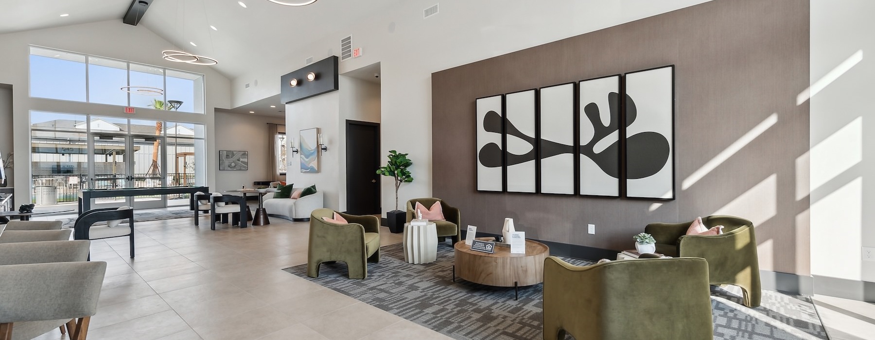 a clubhouse room with chairs a coffee table and a large wall painting